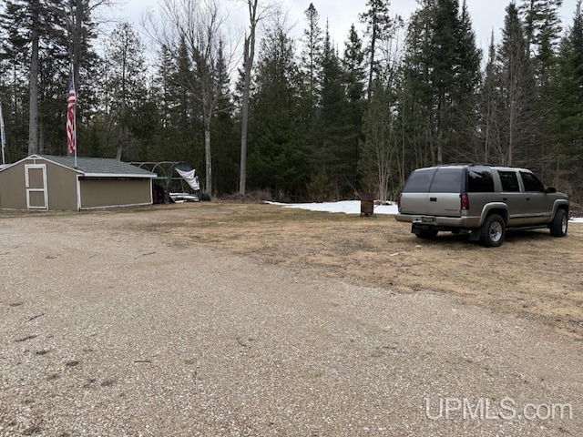 E2903 H44 Rd, Traunik, MI 49891 - view of yard with a shed and a view of trees