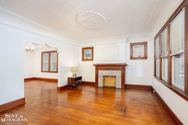1258-1260 Lakepointe St, Grosse Pointe, MI 48230 - living room with wood finished floors, a textured ceiling, a fireplace, and a chandelier