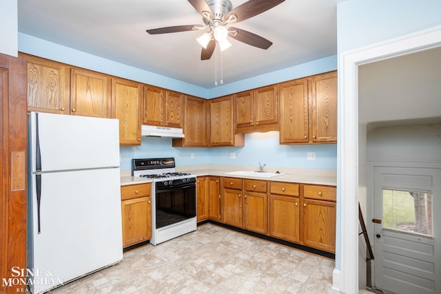 1258-1260 Lakepointe St, Grosse Pointe, MI 48230 - kitchen with freestanding refrigerator, range with gas stovetop, light countertops, brown cabinets, and under cabinet range hood