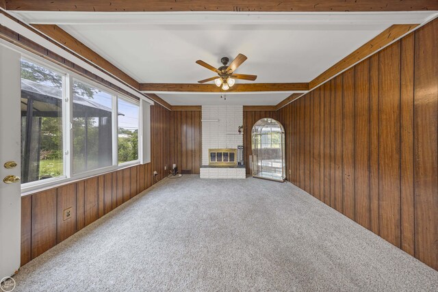 28368 Besmore Dr, Warren, MI 48093 - unfurnished living room with wood walls, beamed ceiling, plenty of natural light, carpet flooring, and ceiling fan