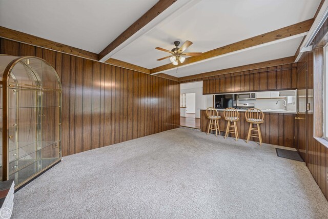 28368 Besmore Dr, Warren, MI 48093 - carpeted living area with wood walls, beamed ceiling, and ceiling fan