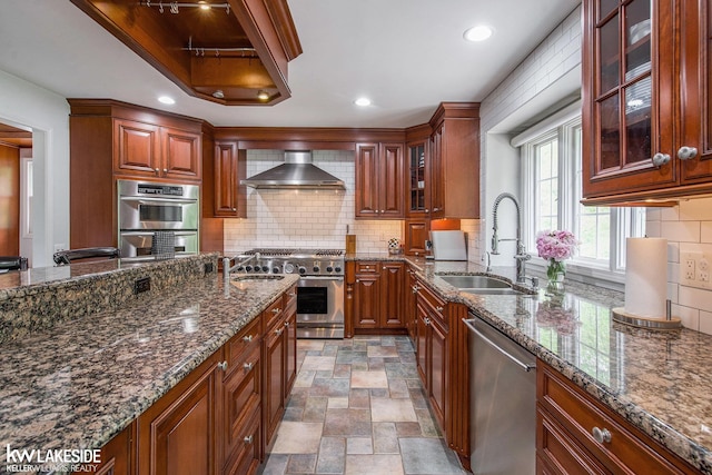 25986 Glenmoor St, Novi, MI 48374 - kitchen featuring stainless steel appliances, wall chimney exhaust hood, dark stone counters, backsplash, and recessed lighting