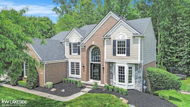 25986 Glenmoor St, Novi, MI 48374 - traditional home with a shingled roof, stone siding, and brick siding