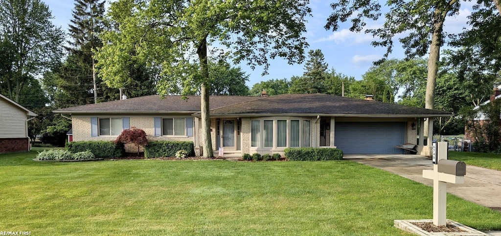 6748 Yarborough Dr, Shelby Twp, MI 48316 - single story home with an attached garage, concrete driveway, brick siding, and a front lawn
