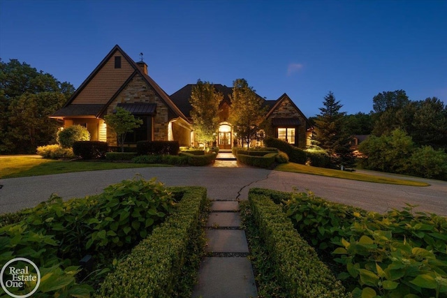 2940 Buell Rd, Oakland Twp, MI 48363 - view of front of house with a chimney, stone siding, and curved driveway