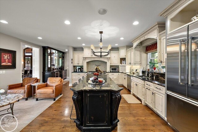 2940 Buell Rd, Oakland Twp, MI 48363 - kitchen with stainless steel appliances, cream cabinetry, decorative backsplash, a kitchen island, and recessed lighting