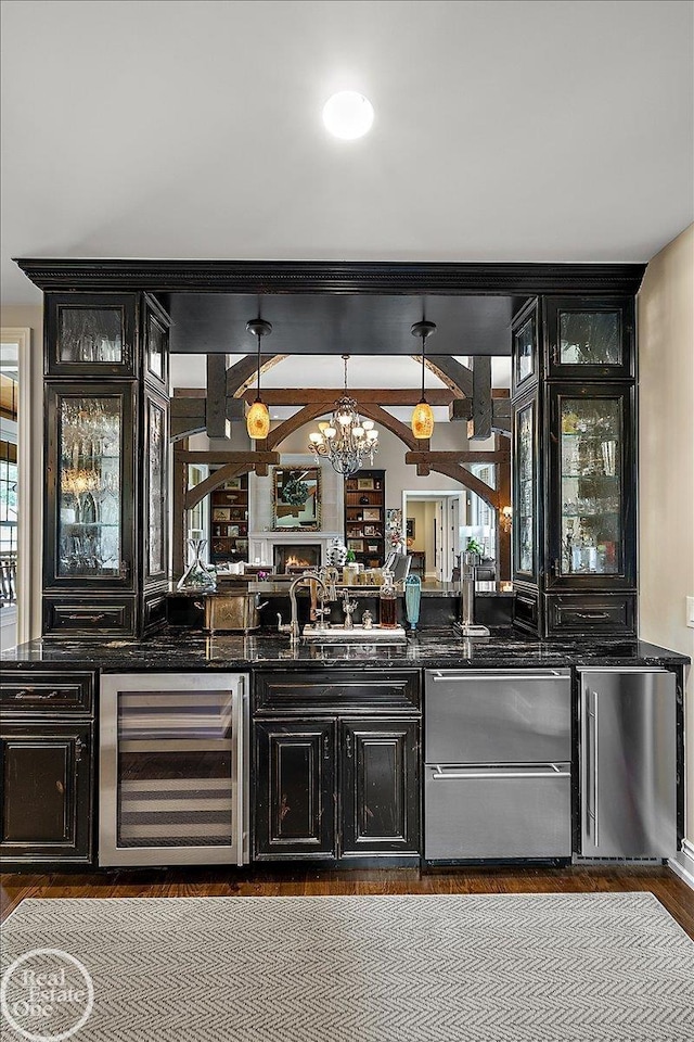 2940 Buell Rd, Oakland Twp, MI 48363 - indoor wet bar with beverage cooler, a chandelier, wood finished floors, pendant lighting, and stainless steel refrigerator