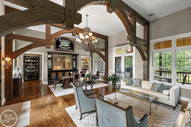 2940 Buell Rd, Oakland Twp, MI 48363 - living room featuring arched walkways, wood finished floors, a high ceiling, and a chandelier