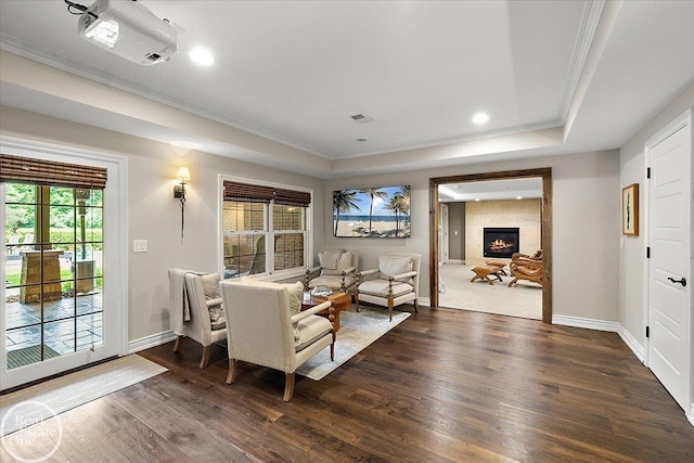 2940 Buell Rd, Oakland Twp, MI 48363 - living area featuring a tray ceiling, dark wood-type flooring, ornamental molding, a tile fireplace, and recessed lighting