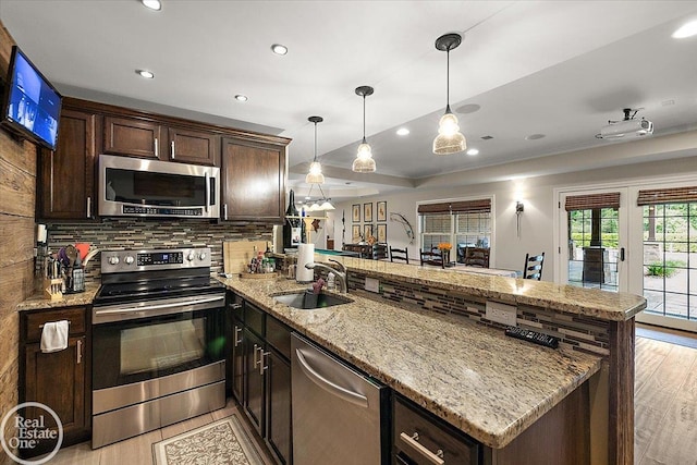 2940 Buell Rd, Oakland Twp, MI 48363 - kitchen featuring stainless steel appliances, a peninsula, light wood-style floors, dark brown cabinets, and recessed lighting