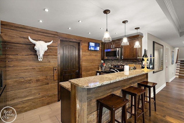 2940 Buell Rd, Oakland Twp, MI 48363 - kitchen with stainless steel microwave, black range with electric stovetop, a peninsula, recessed lighting, and light stone countertops