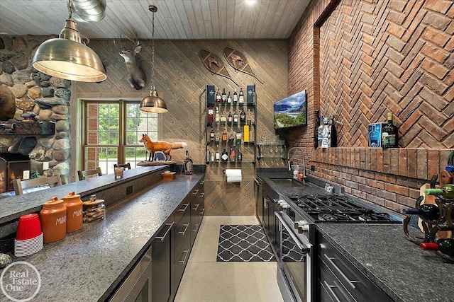 2940 Buell Rd, Oakland Twp, MI 48363 - kitchen featuring stainless steel gas stove, wood walls, dark countertops, pendant lighting, and wooden ceiling