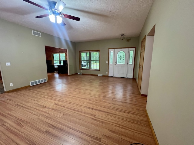 876 N Sanford Ln, Au Gres, MI 48703 - unfurnished living room with light wood-style flooring, ceiling fan, and a textured ceiling