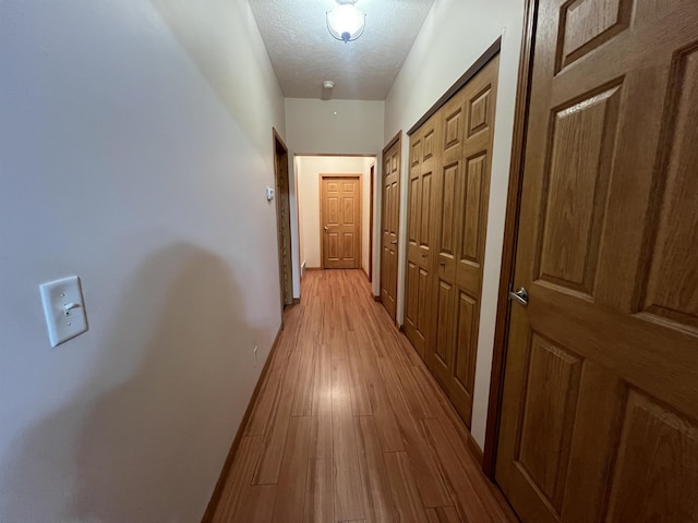 876 N Sanford Ln, Au Gres, MI 48703 - hallway featuring a textured ceiling and light wood-style flooring