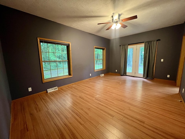 876 N Sanford Ln, Au Gres, MI 48703 - spare room featuring light wood finished floors, a ceiling fan, and a textured ceiling