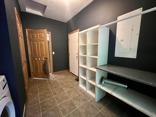 876 N Sanford Ln, Au Gres, MI 48703 - interior space featuring electric panel, a textured ceiling, washer / clothes dryer, and dark tile patterned floors