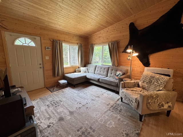 E8310 County Road 440th Hwy, Wetmore, MI 49895 - living room featuring lofted ceiling, wood finished floors, heating unit, and wood walls