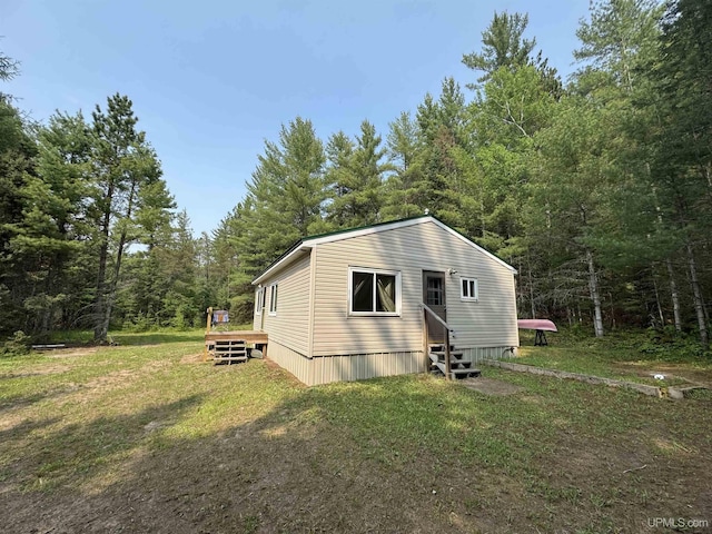 E8310 County Road 440th Hwy, Wetmore, MI 49895 - view of home's exterior featuring entry steps, a wooden deck, a wooded view, and a yard