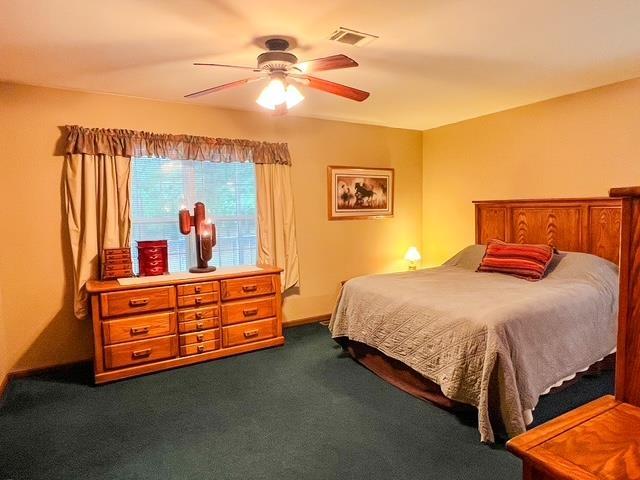 8855 Scotty Dr, Lake, MI 48632 - bedroom with dark colored carpet and ceiling fan