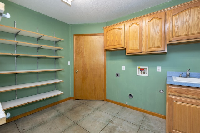 3833 Hermansau Rd, Saginaw, MI 48603 - laundry room with hookup for a washing machine, cabinet space, electric dryer hookup, a textured ceiling, and light tile patterned floors