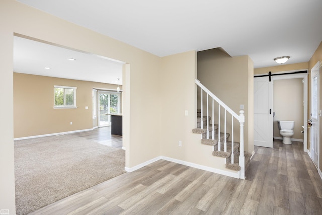 46395 Greenbriar St, Chesterfield Twp, MI 48051 - staircase with a barn door, wood finished floors, and a chandelier