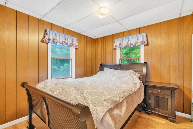 1159 S Lakeshore Rd, Carsonville, MI 48419 - bedroom with a drop ceiling, multiple windows, light wood-style flooring, and wooden walls