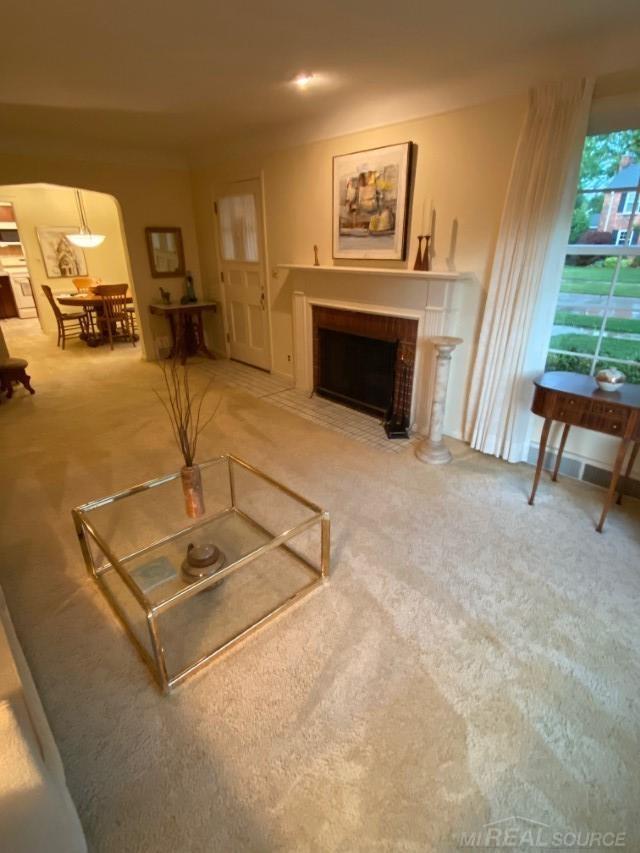 1782 Hollywood St, Grosse Pointe Woods, MI 48236 - living area with carpet, a fireplace with flush hearth, and arched walkways