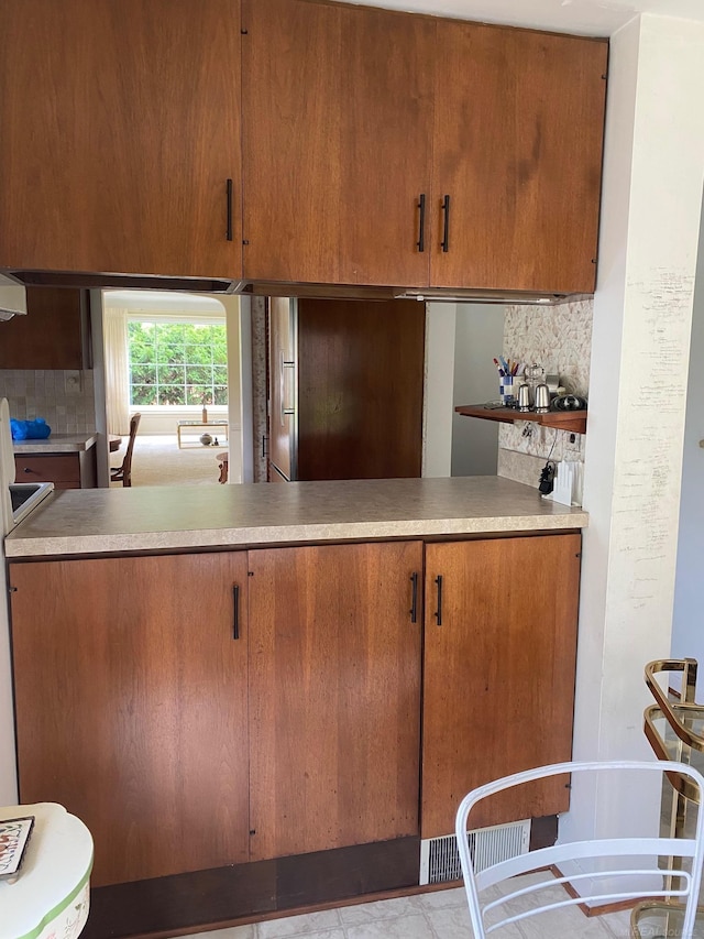 1782 Hollywood St, Grosse Pointe Woods, MI 48236 - kitchen featuring tasteful backsplash, brown cabinetry, and light countertops