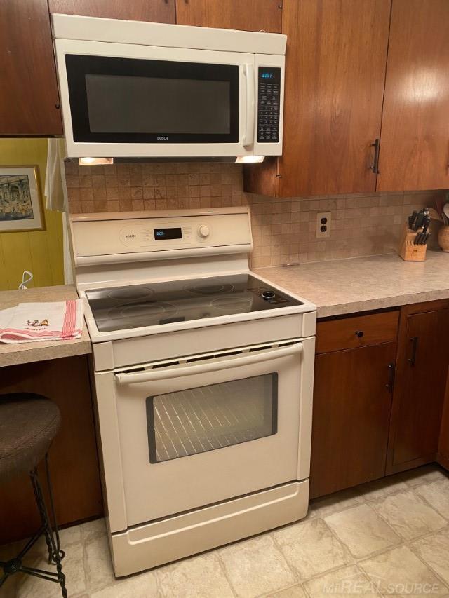 1782 Hollywood St, Grosse Pointe Woods, MI 48236 - kitchen featuring white appliances, light countertops, and tasteful backsplash