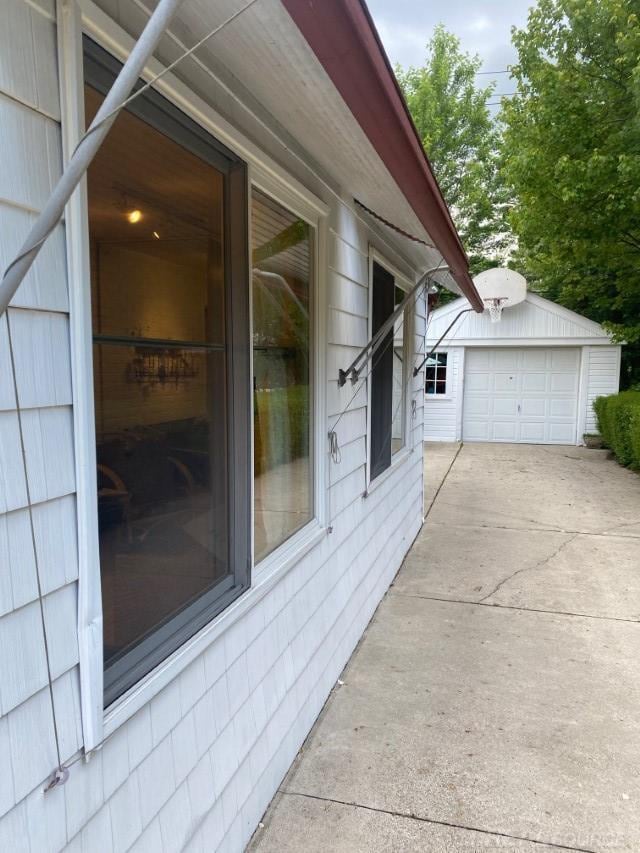 1782 Hollywood St, Grosse Pointe Woods, MI 48236 - view of side of property featuring an outdoor structure, a detached garage, and driveway