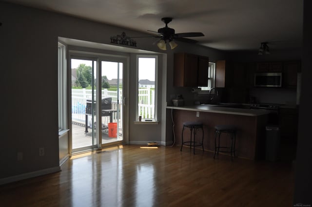 9180 Woodridge Dr, Davison, MI 48423 - kitchen with a kitchen breakfast bar, wood finished floors, a ceiling fan, a peninsula, and light countertops
