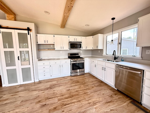 3331 Lakeshore Dr, Gladwin, MI 48624 - kitchen with appliances with stainless steel finishes, light wood finished floors, light countertops, and white cabinets