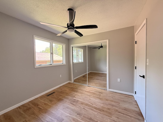3331 Lakeshore Dr, Gladwin, MI 48624 - unfurnished bedroom featuring a textured ceiling, light wood finished floors, a closet, and ceiling fan