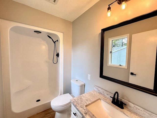 3331 Lakeshore Dr, Gladwin, MI 48624 - full bath with vanity, wood finished floors, a shower, and a textured ceiling