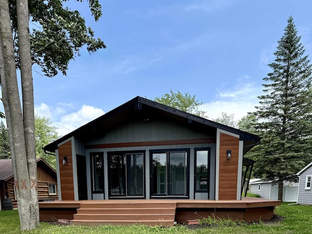 3331 Lakeshore Dr, Gladwin, MI 48624 - rear view of property featuring a sunroom and a deck