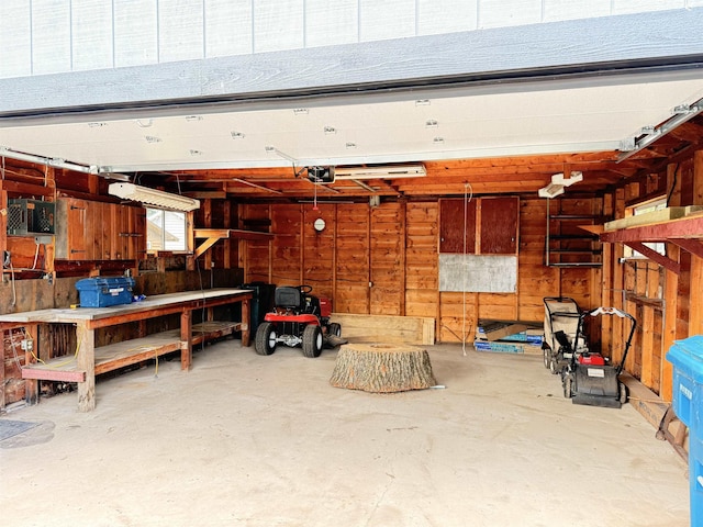 3331 Lakeshore Dr, Gladwin, MI 48624 - garage with a garage door opener, wood walls, and a workshop area