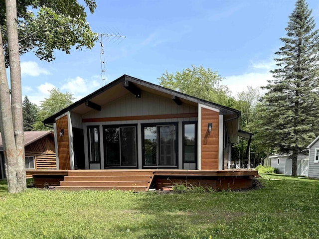 3331 Lakeshore Dr, Gladwin, MI 48624 - back of house with a sunroom and a lawn
