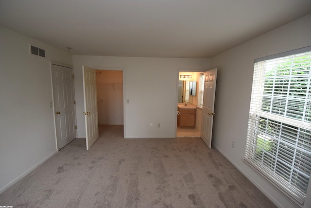11186 Spruce Ct Unit 105, Washington Twp, MI 48094 - unfurnished bedroom featuring light colored carpet, ensuite bathroom, a spacious closet, and a closet