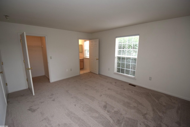 11186 Spruce Ct Unit 105, Washington Twp, MI 48094 - unfurnished bedroom featuring light carpet, a walk in closet, and a closet