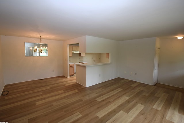 11186 Spruce Ct Unit 105, Washington Twp, MI 48094 - unfurnished living room with light wood finished floors and a chandelier