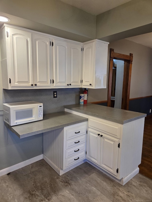321 Lamson St, Grand Ledge, MI 48837 - kitchen with white microwave, white cabinets, and a peninsula