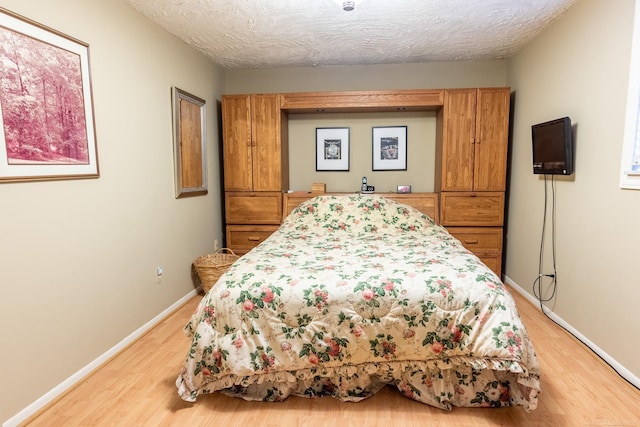 38114 Huron Pointe Dr, Harrison Twp, MI 48045 - bedroom with light wood-style floors and a textured ceiling