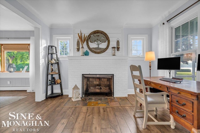 421 Edgewater Dr, Algonac, MI 48001 - home office with wood-type flooring, a brick fireplace, and a baseboard heating unit