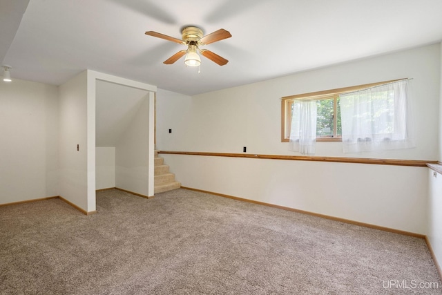 719 S Carlshend Rd, Skandia, MI 49885 - empty room featuring carpet flooring, ceiling fan, and stairway