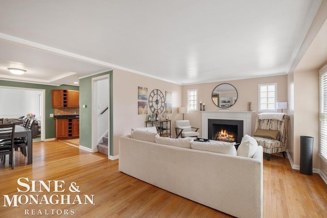 1387 Torrey Rd, Grosse Pointe Woods, MI 48236 - living area featuring a brick fireplace, stairway, light wood-type flooring, ornamental molding, and healthy amount of natural light
