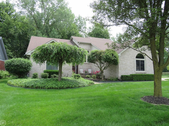 46778 Tiffin Ct, Chesterfield, MI 48047 - obstructed view of property featuring brick siding, a front lawn, and a shingled roof