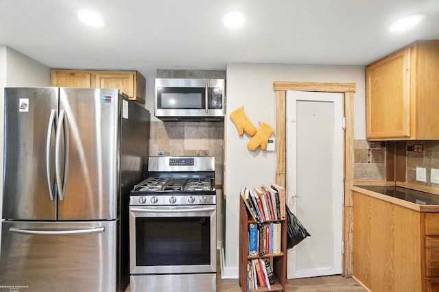 618 Harrison St, Monroe, MI 48161 - kitchen with appliances with stainless steel finishes, tasteful backsplash, recessed lighting, wood finished floors, and light brown cabinetry