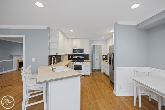870 Crescent Ln, Grosse Pointe Woods, MI 48236 - kitchen with appliances with stainless steel finishes, open shelves, a peninsula, white cabinets, and ornamental molding