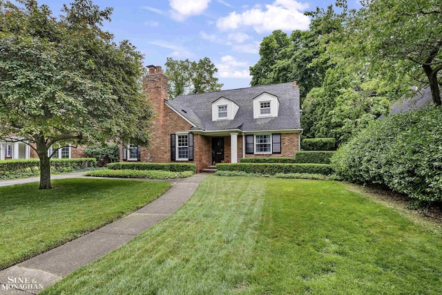 388 Lincoln Rd, Grosse Pointe, MI 48230 - cape cod home with brick siding, a front lawn, and a chimney