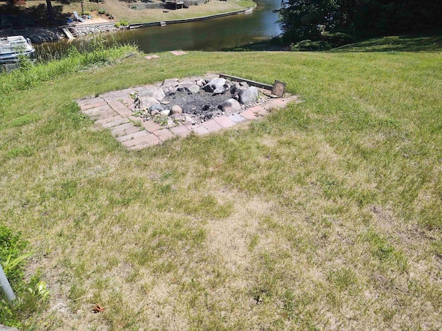 3601 Huckleberry Trl, Farwell, MI 48622 - view of green lawn featuring a fire pit and a water view